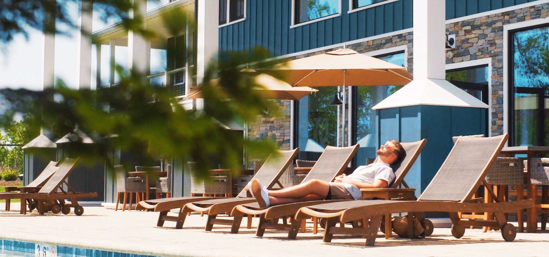 A guest enjoys a sunny day by the pool at The Preserve Resort & Spa.