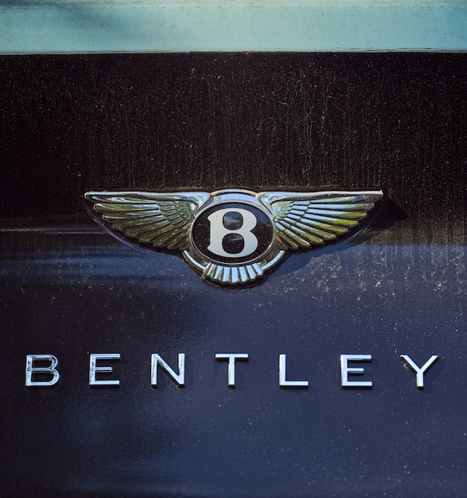 The image shows the Bentley logo and emblem on a vehicle. The emblem features a winged 